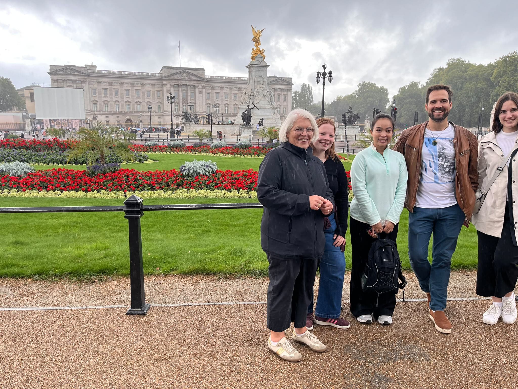 A BeExplorers group in front of Buckingham Palace on a rainy morning