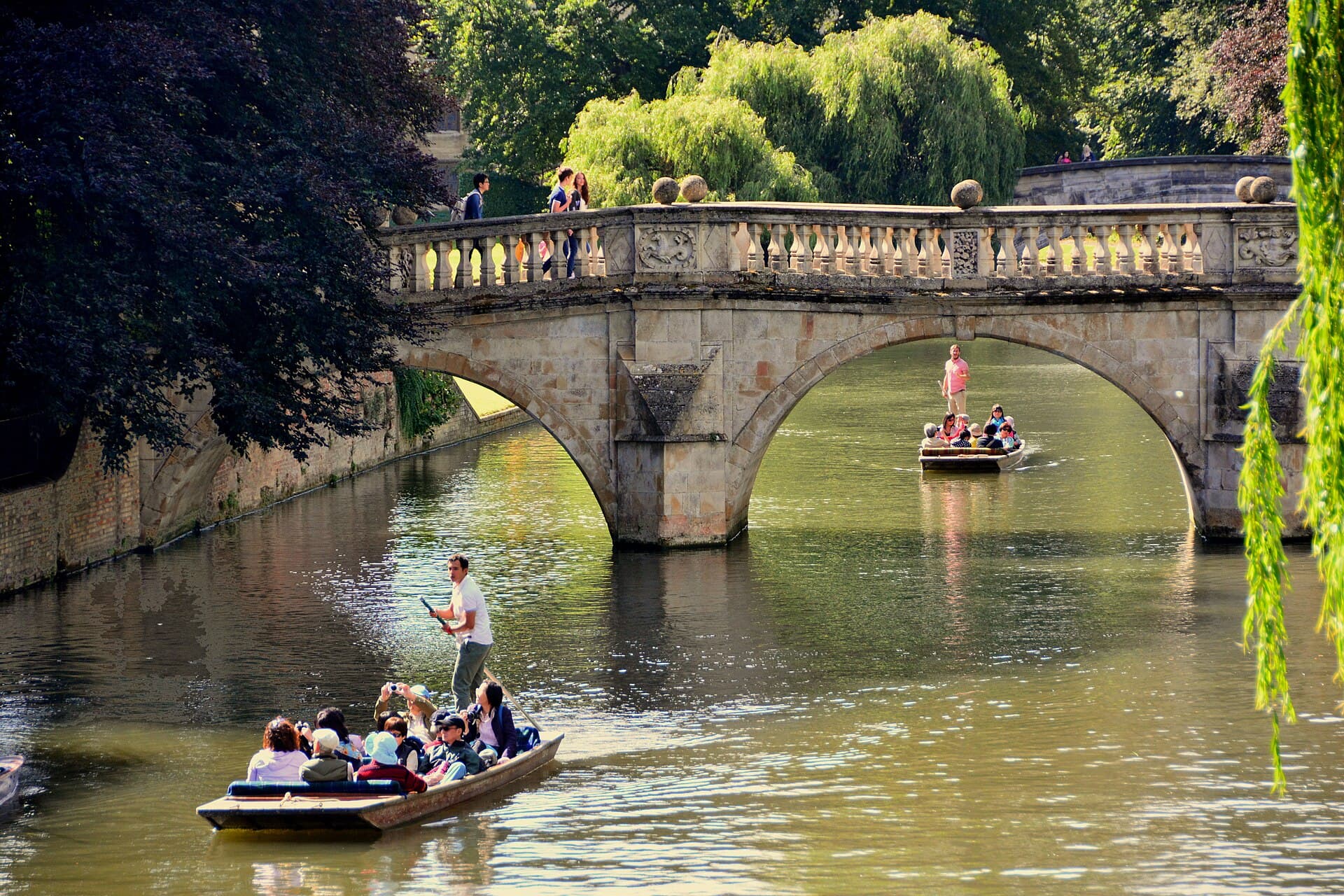 Punts passing under Clare Bridge on the River Cam in Cambridge